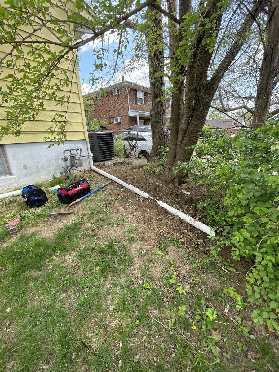 Excavated water service line trench beside a Cincinnati home — DE Plumbing, Cincinnati